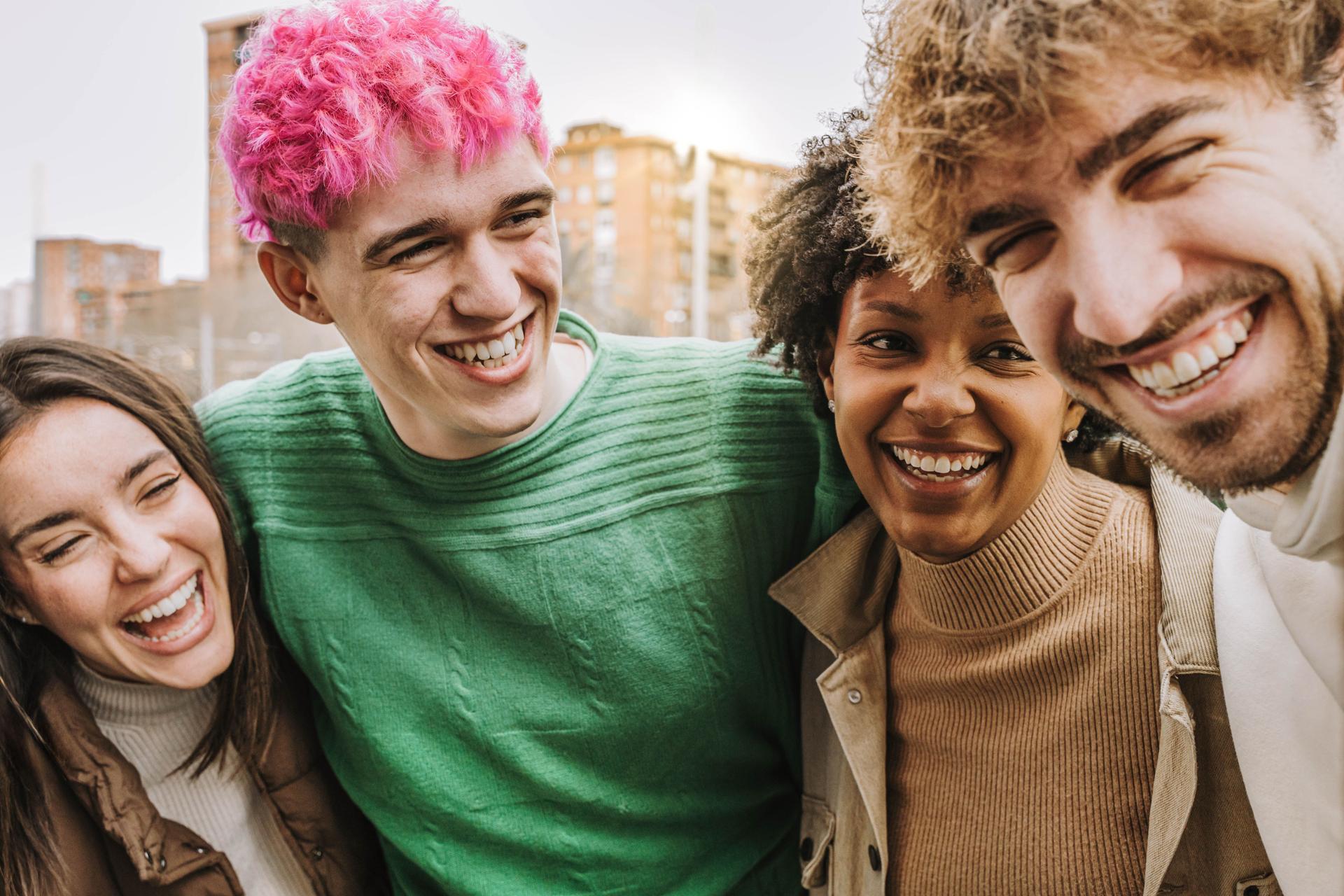 Happy friends having fun laughing together - Group of multiracial people hugging and smiling outdoors - People and friendship concept